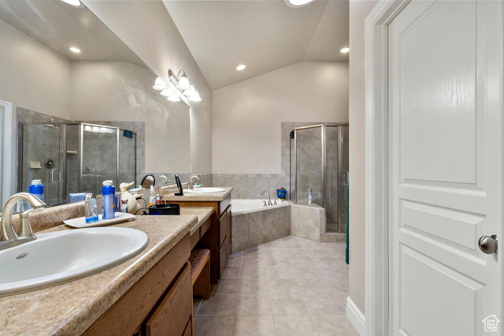 Bathroom featuring independent shower and bath, dual sinks, vaulted ceiling, and oversized vanity