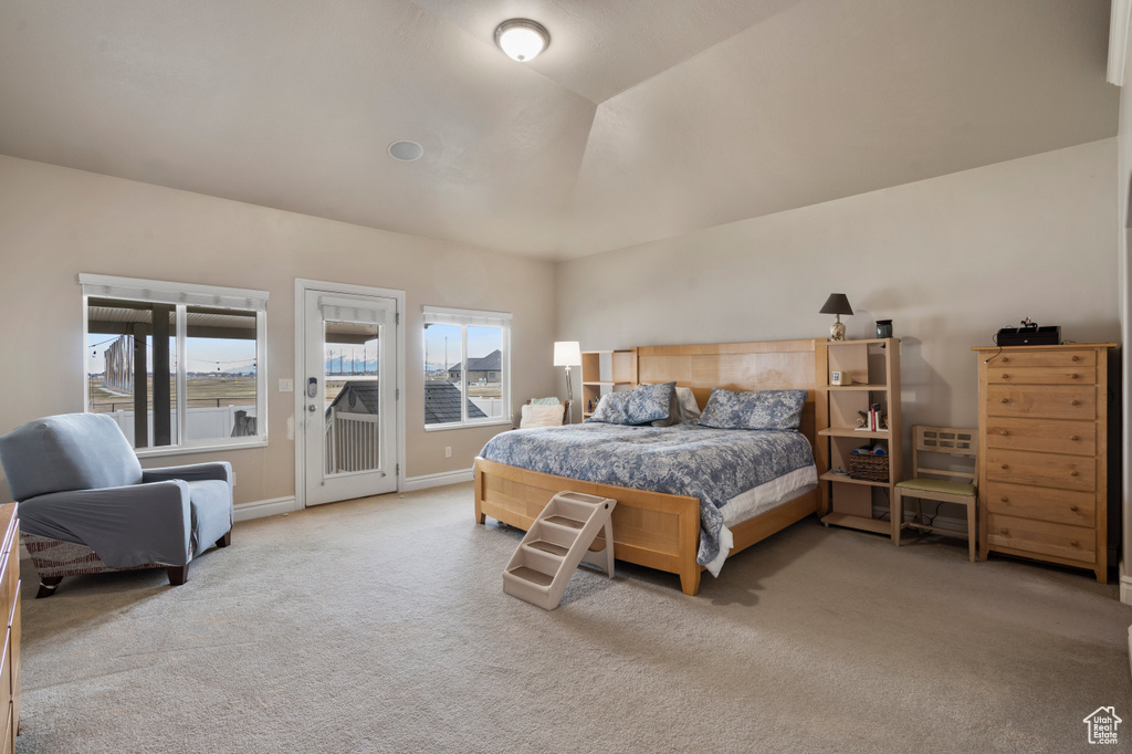 Carpeted bedroom featuring access to exterior and vaulted ceiling