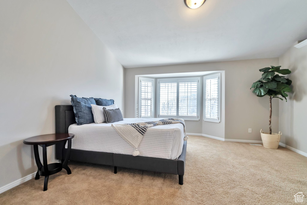 Bedroom featuring vaulted ceiling and light colored carpet