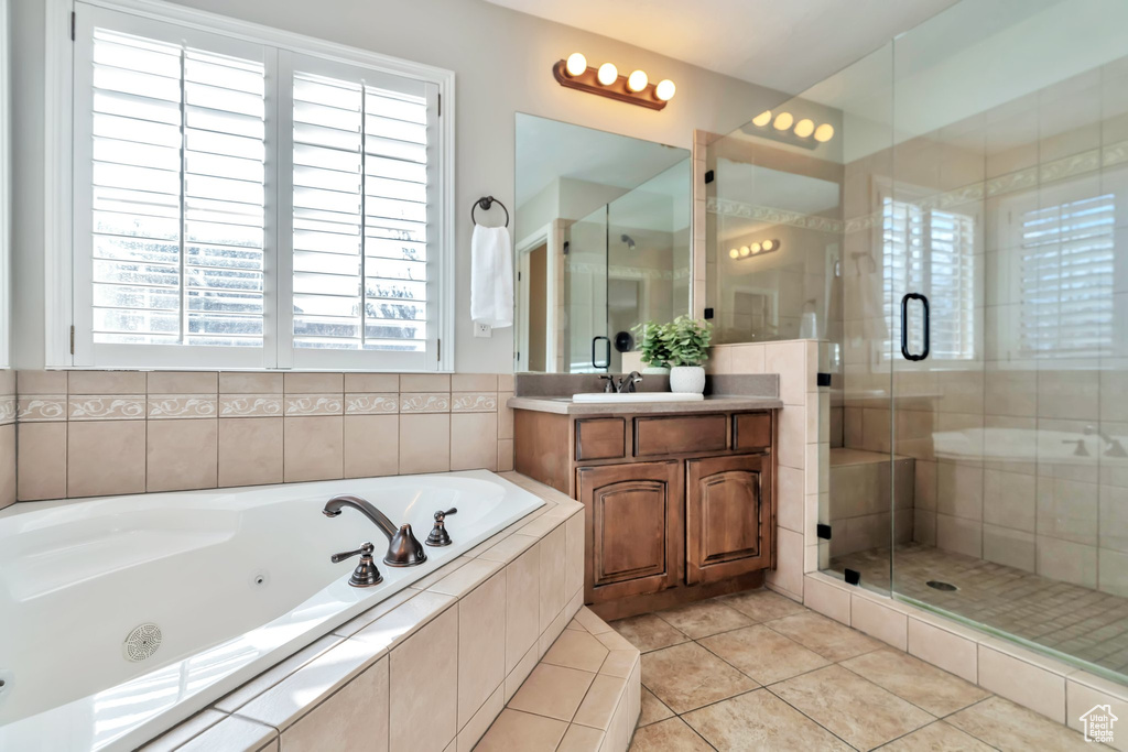 Bathroom featuring plenty of natural light, plus walk in shower, tile floors, and oversized vanity
