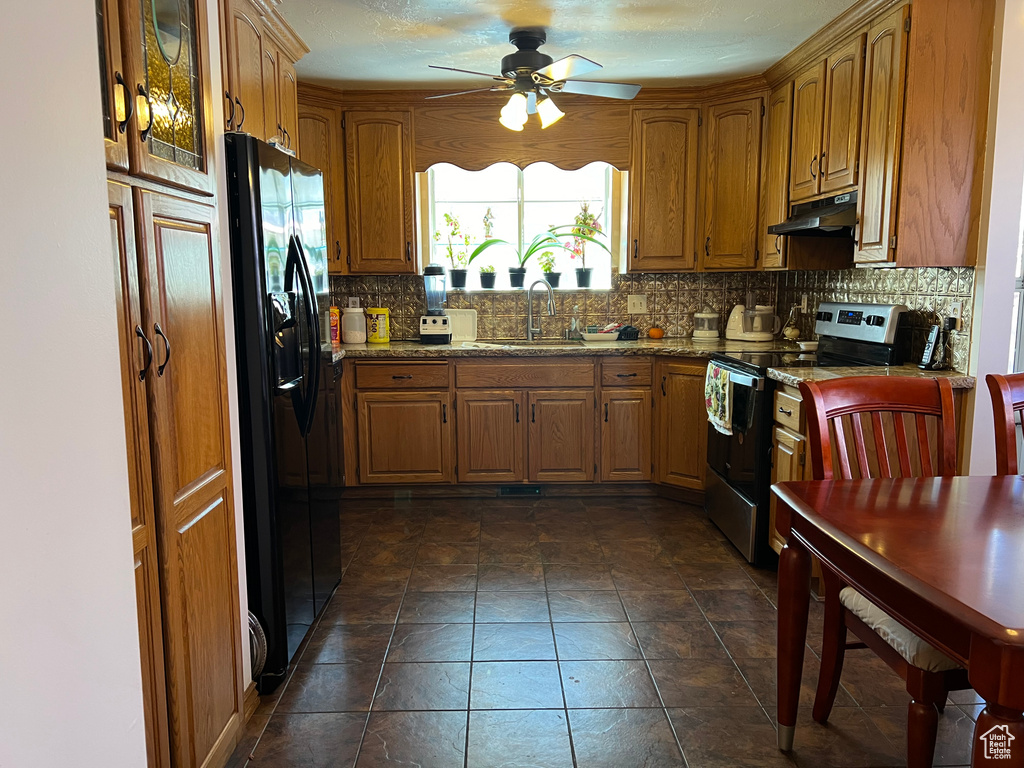 Kitchen with backsplash, ceiling fan, sink, electric range, and black refrigerator with ice dispenser