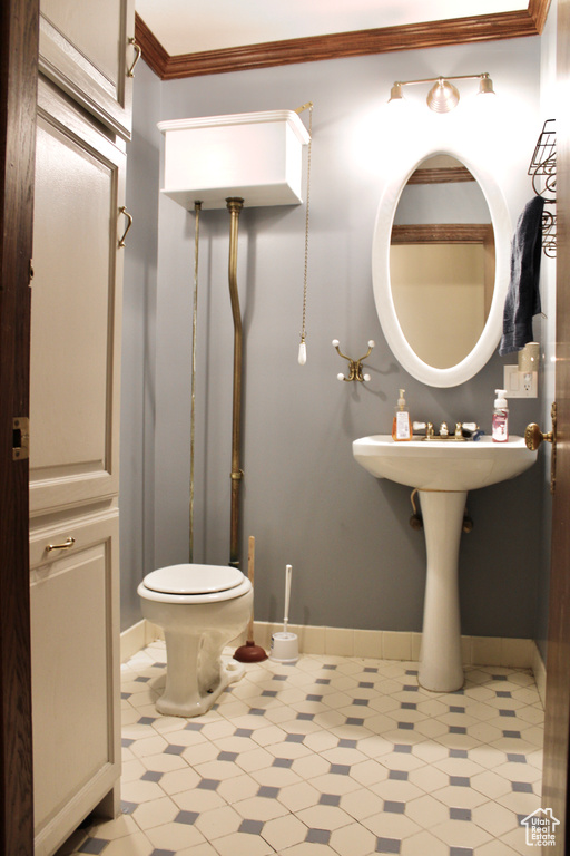 Bathroom featuring tile flooring, ornamental molding, and toilet