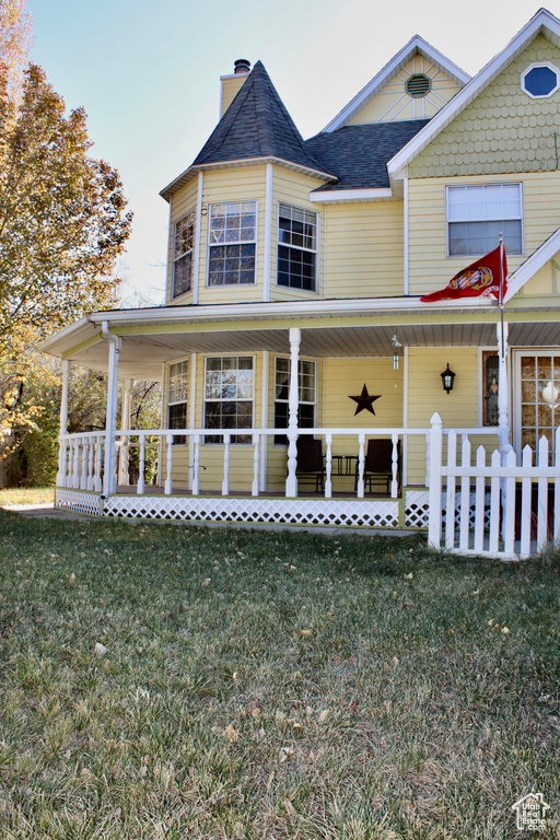 View of front facade with a front yard and covered porch