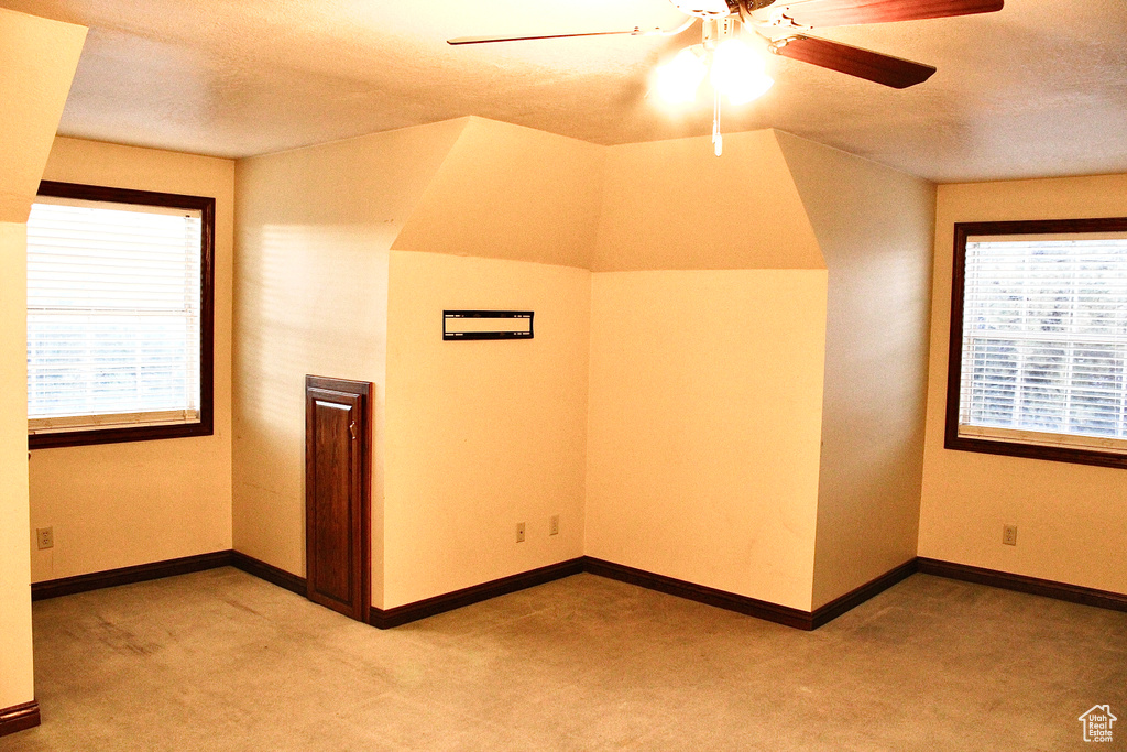 Bonus room with light carpet and ceiling fan