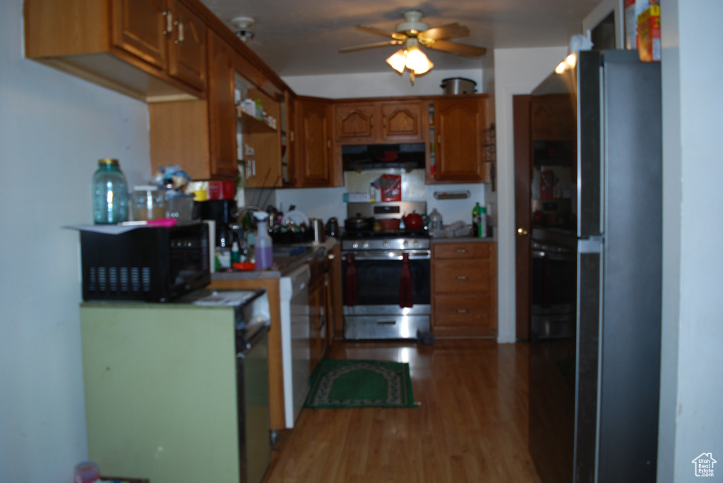 Kitchen featuring black appliances, light wood-type flooring, and ceiling fan