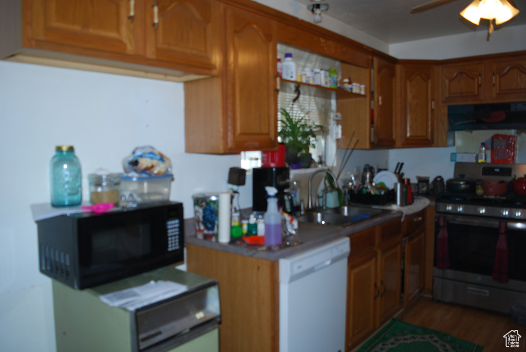 Kitchen featuring range, sink, dishwasher, fume extractor, and ceiling fan