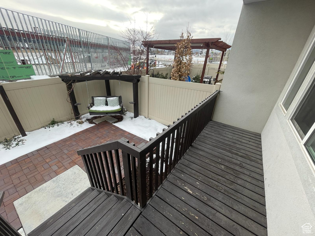 Snow covered deck featuring a patio