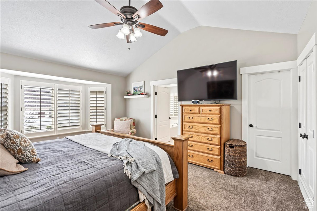 Bedroom featuring vaulted ceiling, a closet, dark carpet, and ceiling fan
