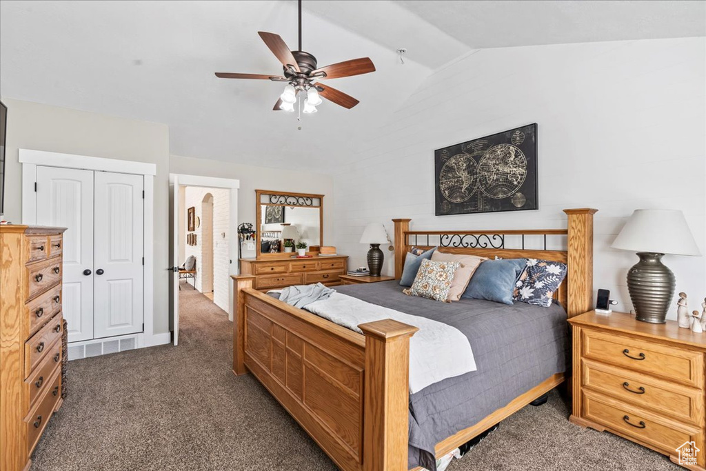 Bedroom featuring ceiling fan, dark colored carpet, lofted ceiling, and a closet