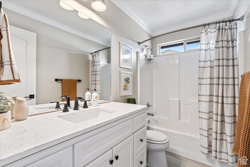 Full bathroom with toilet, crown molding, large vanity, and shower / tub combo
