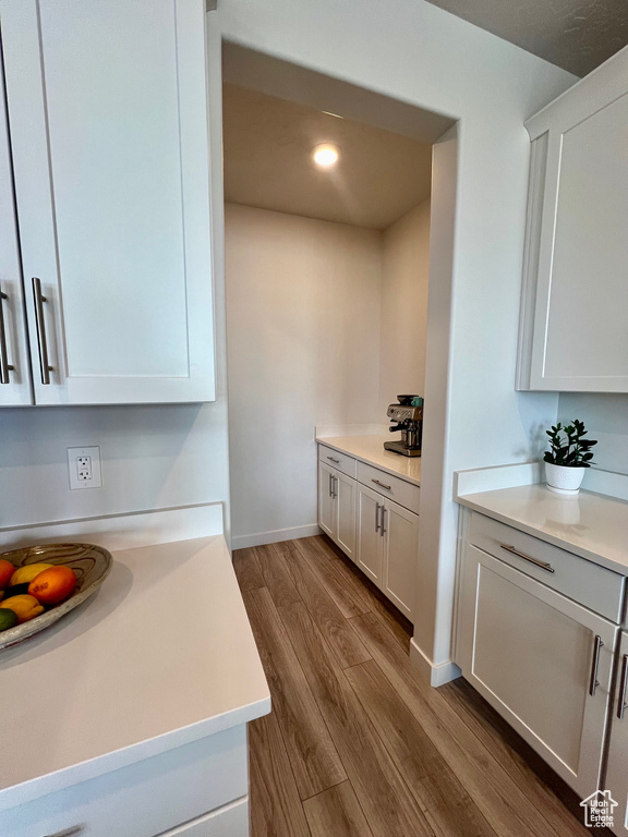 Kitchen with white cabinets and hardwood / wood-style flooring