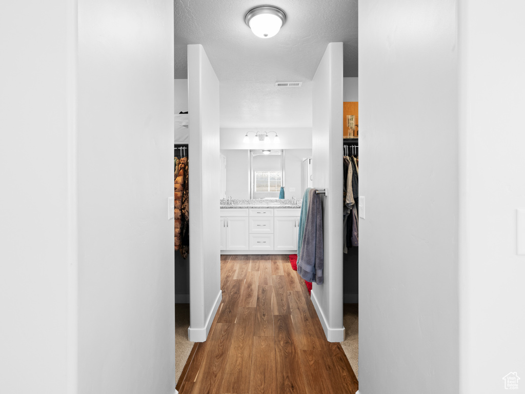 Hallway featuring sink and light hardwood / wood-style flooring
