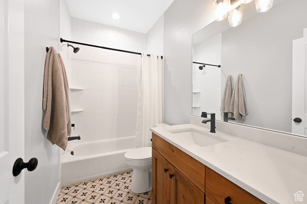 Full bathroom featuring toilet, tile flooring, large vanity, and shower / tub combo with curtain