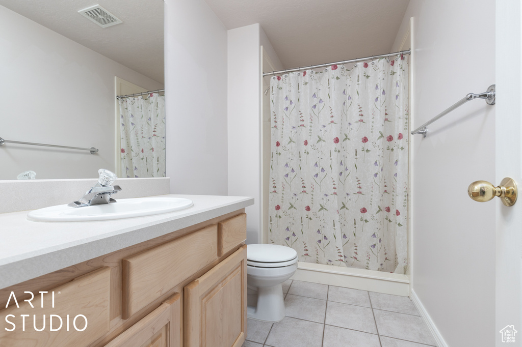 Bathroom with tile floors, toilet, and oversized vanity