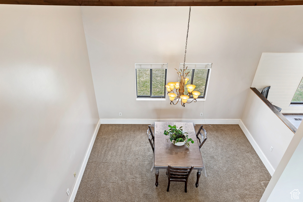 Dining area with a notable chandelier, light carpet, and a healthy amount of sunlight