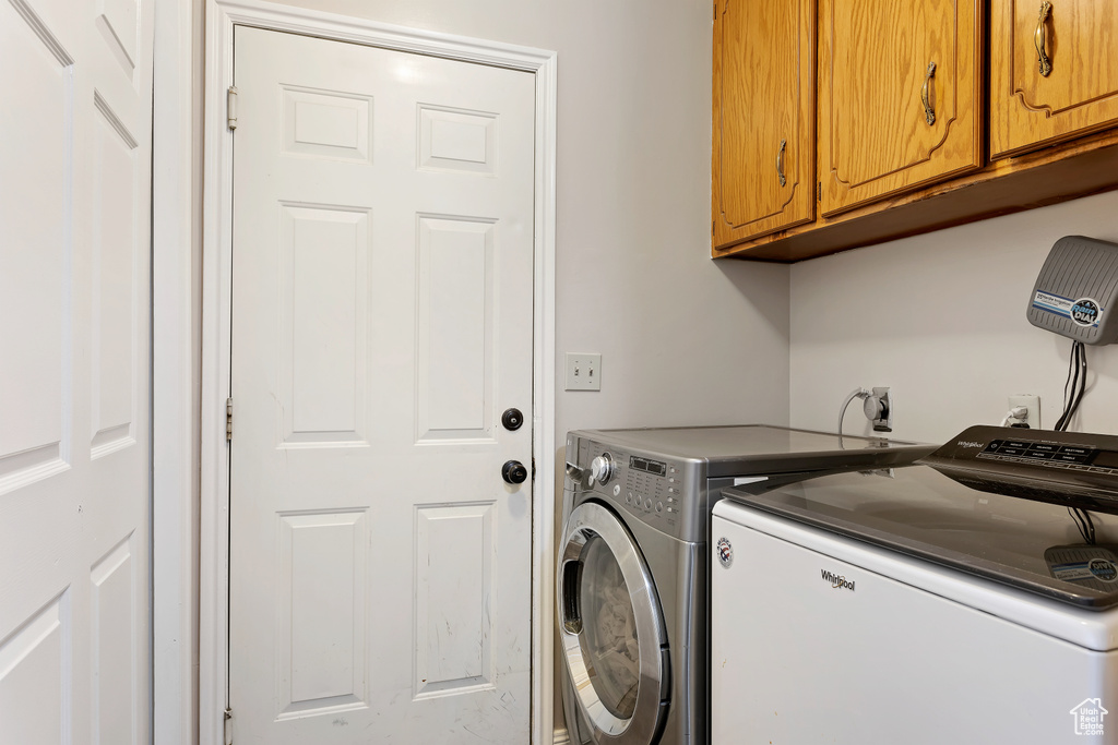 Washroom featuring cabinets, separate washer and dryer, and hookup for an electric dryer