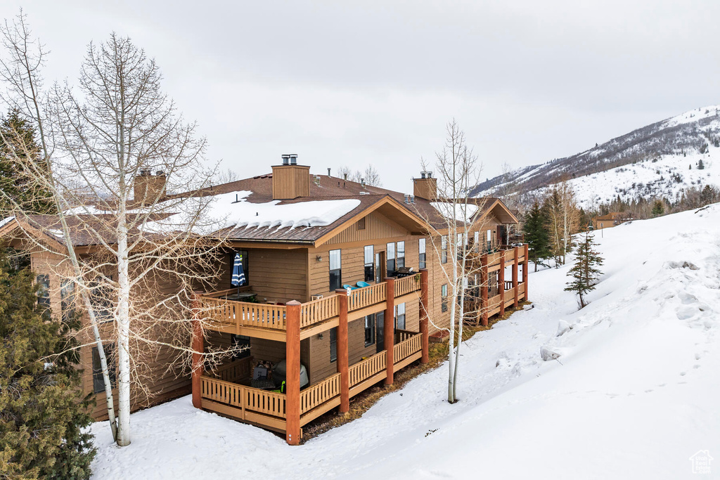 Snow covered house featuring a wooden deck