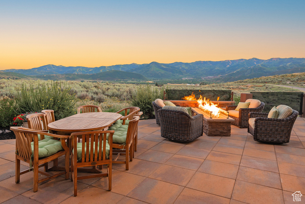Patio terrace at dusk with a mountain view and a fire pit