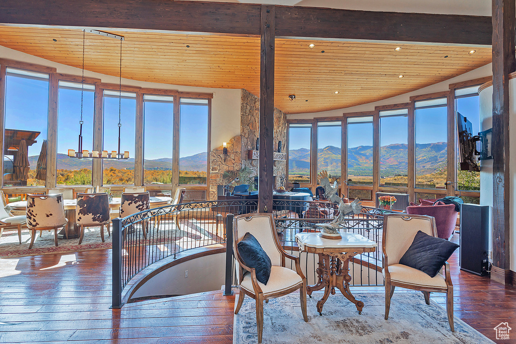 Sunroom featuring vaulted ceiling, a mountain view, an inviting chandelier, and wood ceiling