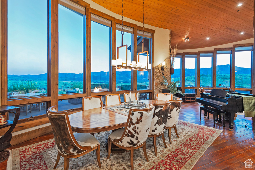 Dining area with a mountain view, dark hardwood / wood-style flooring, and wood ceiling