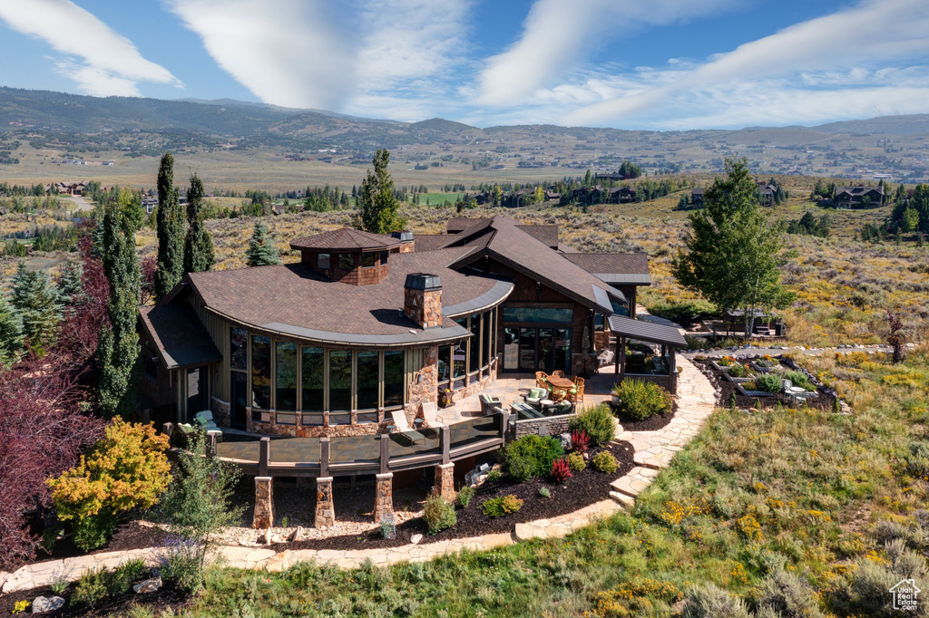 Rear view of property with a mountain view, a patio, and an outdoor hangout area