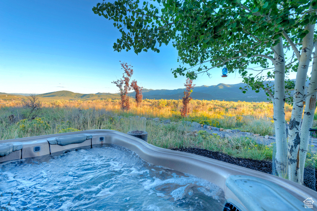 View of swimming pool featuring an outdoor hot tub and a mountain view