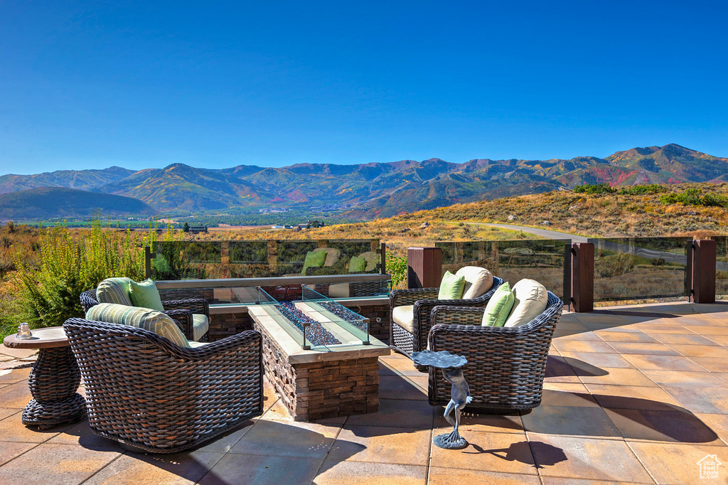 View of patio / terrace with an outdoor fire pit and a mountain view