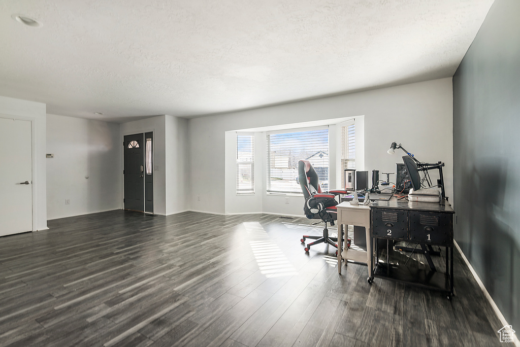 Office area featuring dark wood-type flooring and a textured ceiling