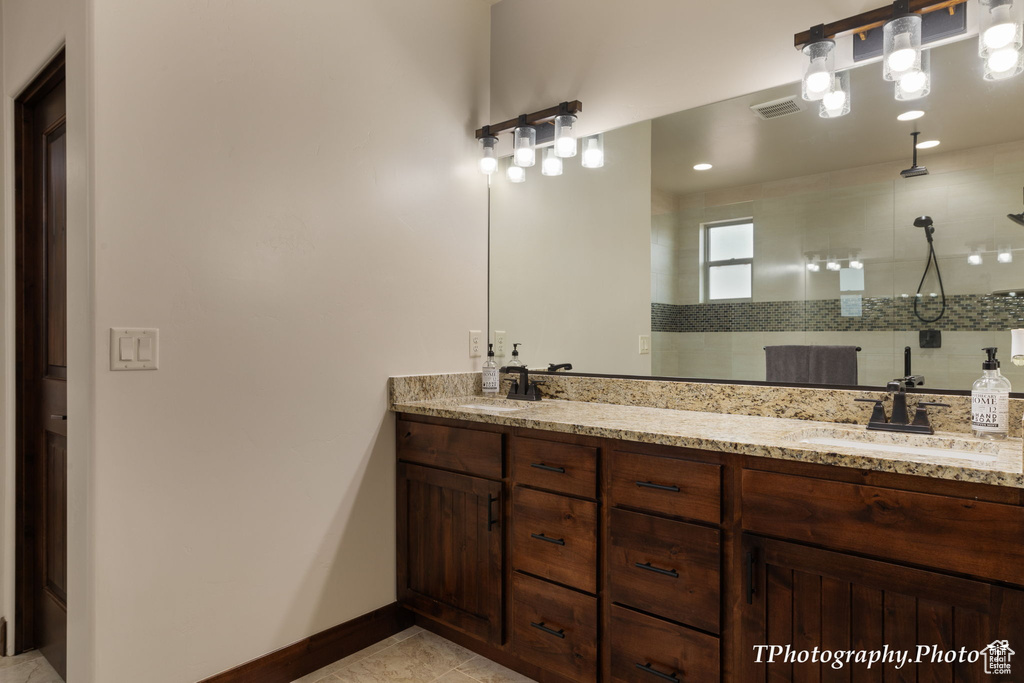 Bathroom featuring dual bowl vanity and tile flooring