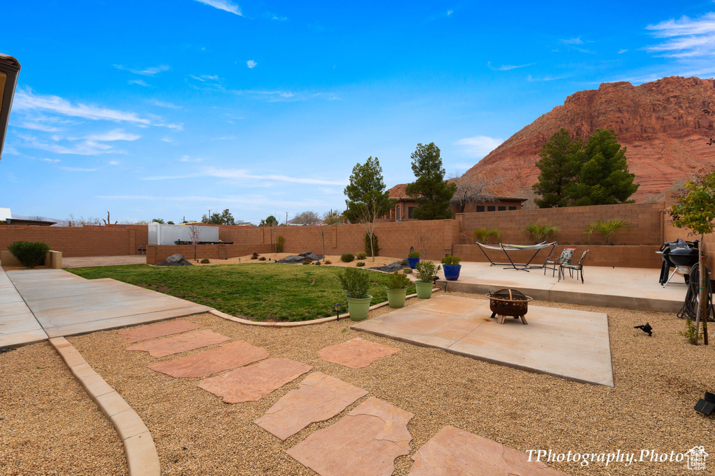 View of yard featuring a patio, a mountain view, and a fire pit
