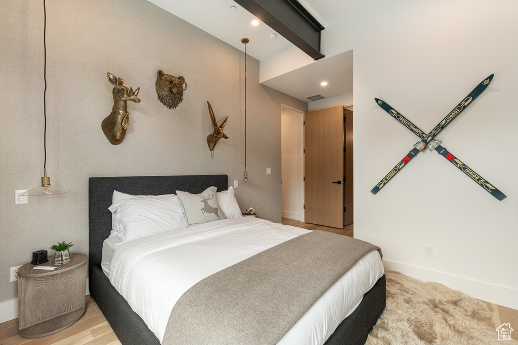 Bedroom featuring beamed ceiling and light hardwood / wood-style flooring