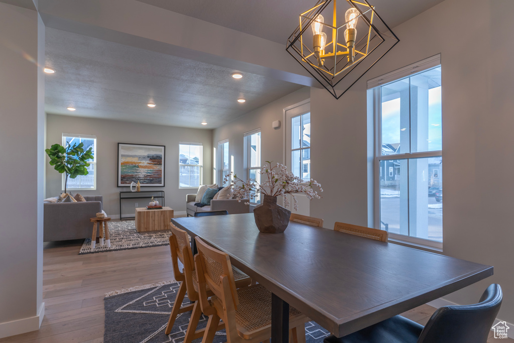 Dining area featuring an inviting chandelier, plenty of natural light, and hardwood / wood-style floors