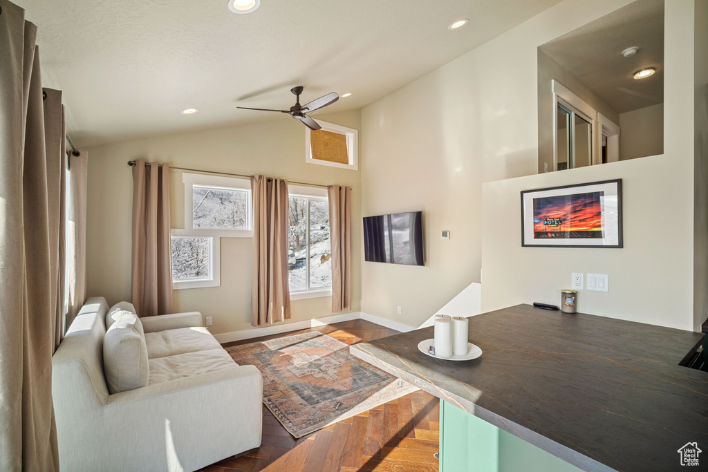Living room featuring vaulted ceiling and ceiling fan