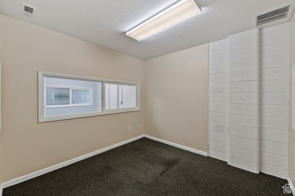 Carpeted spare room featuring a textured ceiling