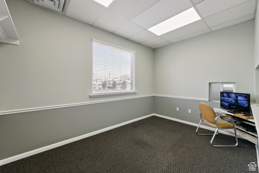 Unfurnished office with dark colored carpet and a paneled ceiling