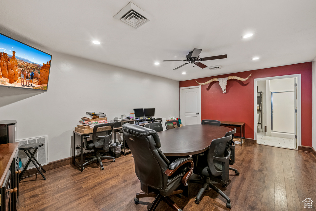 Home office with dark hardwood / wood-style floors and ceiling fan