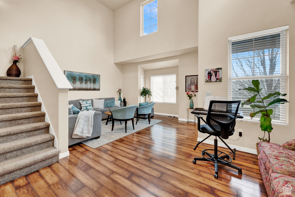Home office with hardwood / wood-style floors and a high ceiling