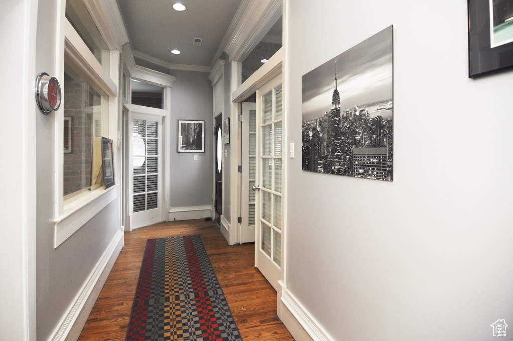 Hallway featuring ornamental molding and dark hardwood / wood-style floors