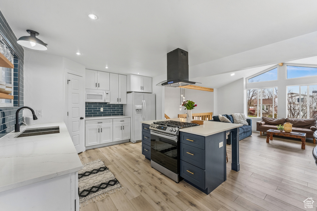 Kitchen with white cabinetry, white appliances, island range hood, and light hardwood / wood-style floors