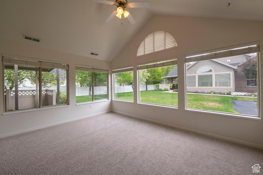Unfurnished sunroom featuring lofted ceiling and ceiling fan