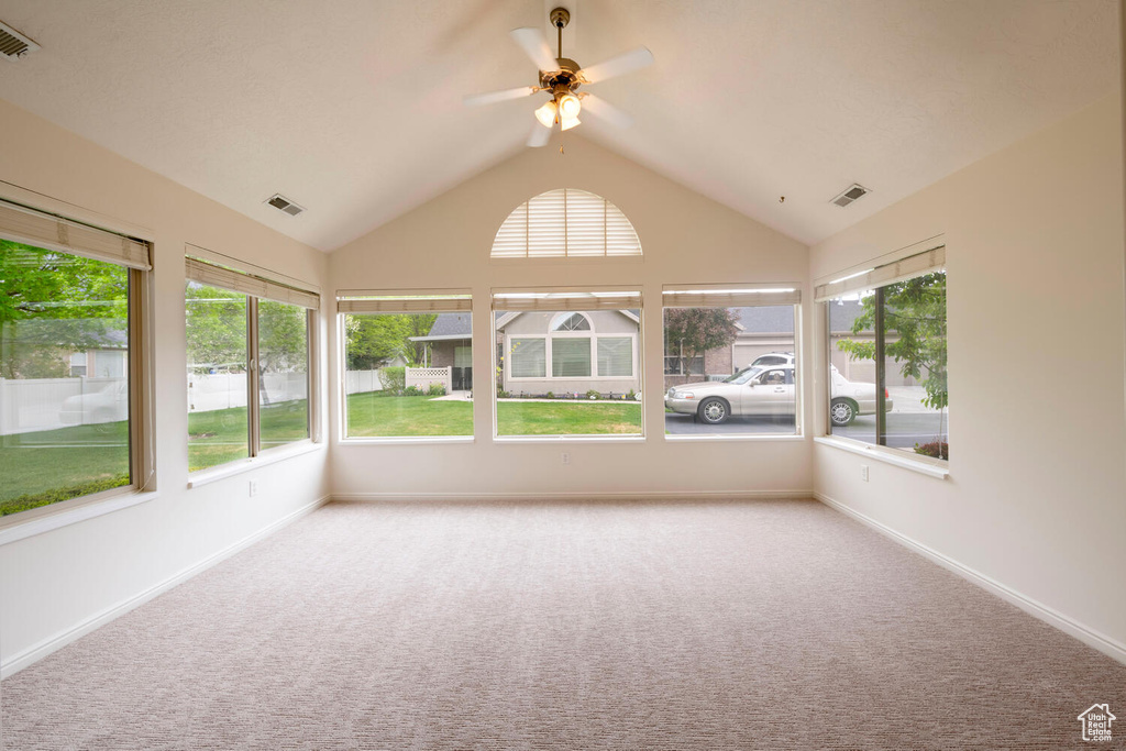 Unfurnished sunroom with ceiling fan and lofted ceiling