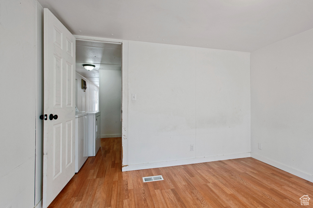 Empty room featuring light hardwood / wood-style flooring and washer / clothes dryer