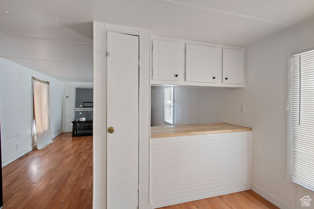 Kitchen featuring white cabinetry and light hardwood / wood-style flooring