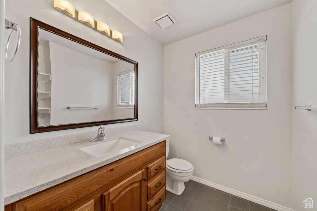 Bathroom featuring toilet, tile flooring, and oversized vanity