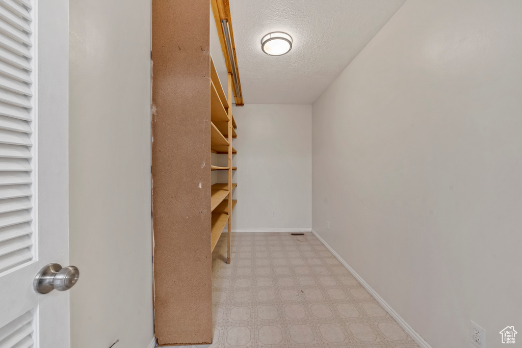 Walk in closet with light tile flooring