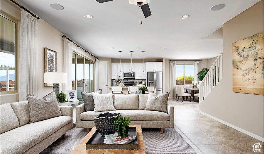 Living room featuring light tile floors, a water view, and ceiling fan