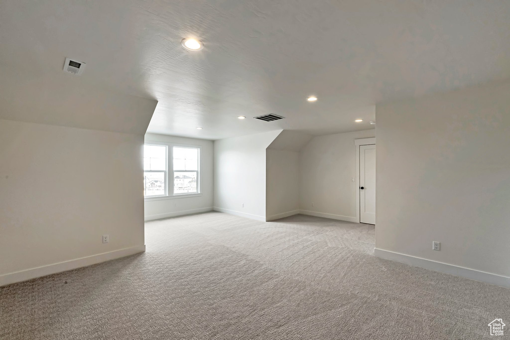 Bonus room featuring light colored carpet