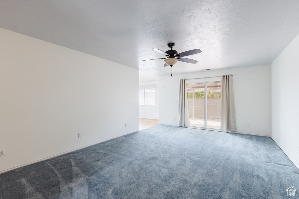 Spare room featuring light carpet and ceiling fan