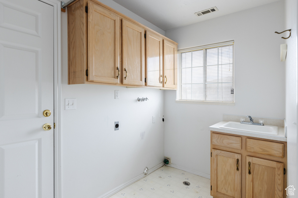 Clothes washing area featuring cabinets, light tile floors, hookup for an electric dryer, sink, and hookup for a gas dryer