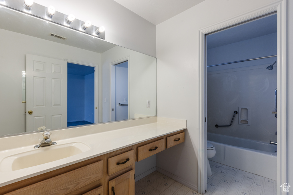 Full bathroom featuring vanity, toilet, tile flooring, and shower / bathing tub combination